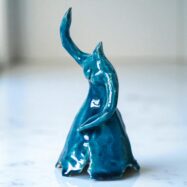 Handmade blue glazed ceramic ballerina sculpture with raised arms and flowing dress, presented in wooden gift box – Dance Is Ceramica