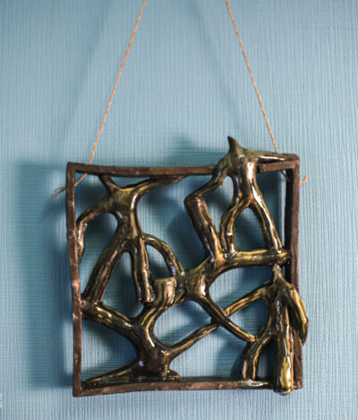 Handmade ceramic wall art with dancing figures in square frame – front view