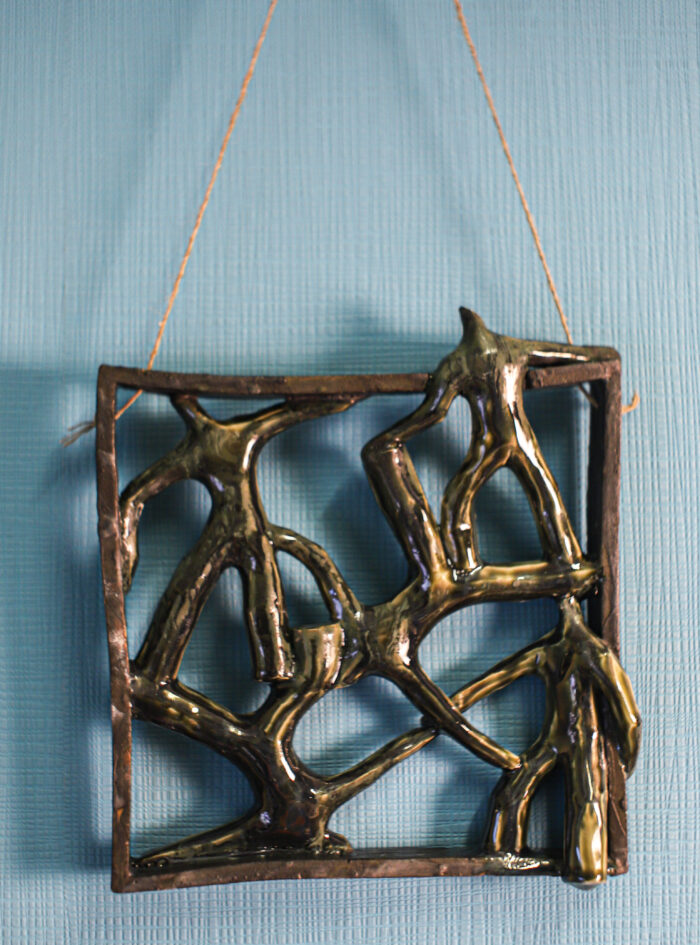 Handmade ceramic wall art with dancing figures in square frame – front view