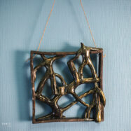 Handmade ceramic wall art with dancing figures in square frame – front view